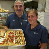 <p>Cacciatori Pizza owner Sal Triarsi and Jennie Pagliuca show off some of their popular pizzas.</p>