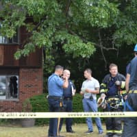 <p>Police and fire officials gather on the front lawn of the two-family home in Paramus.</p>