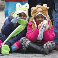 <p>Two girls watch the parade and stay warm in fuzzy hats.</p>