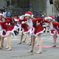 <p>A group of Santa dancers performs for the judging stand at Sunday&#x27;s parade.</p>
