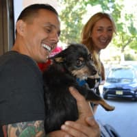 <p>Guerrilla Fitness owner Joe Ghaznavi and Robyn Hendrix play with an adoptable dog.</p>