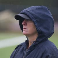 <p>Greeley coach Erin Tracy watches the game in the rain Friday.</p>