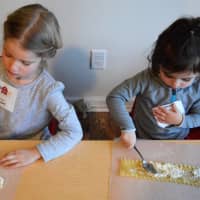 <p>Two little girls intently begin making lasagna roll-ups.</p>