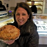 <p>A happy customer holds an apple pie.</p>
