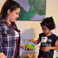 <p>HealthBarn USA Educator Alyssa D&#x27;Amico of Mahwah helps a little chef put finishing touches on a batch of lasagna roll-ups.</p>