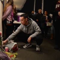 <p>Chris Vidal, 18, places a bouquet of roses under a memorial for Brooke Costanzo at a vigil at Saddle Brook High School Tuesday evening.</p>