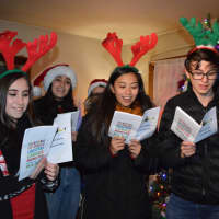 <p>Carolers sing &quot;We Wish You A Merry Christmas&quot; and other holiday favorites in DeFontes&#x27; living room.</p>