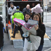 <p>Police officers and volunteers help bring toys from the trailers into Hackensack University Medical Center.</p>