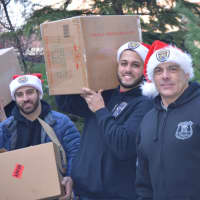 <p>Fairview Chief Marty Kahn and two Fairview officers bring toys into the hospital.</p>