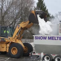 <p>A backhoe loads snow into the Snow Melter.</p>
