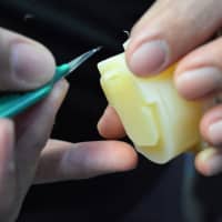 <p>Hand trimming a plastic part infused with vitamin E.</p>