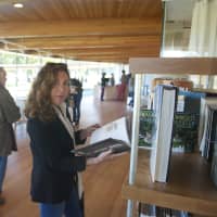 <p>A visitor checks out books in the library at Grace Farms.</p>