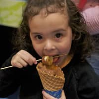 <p>A young girl enjoys a chocolate treat at the Chocolate Expo at the Maritime Aquarium at Norwalk on Sunday.</p>
