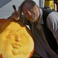 <p>Artist Deane Arnold carves a huge pumpkin at Harvest Fest.</p>