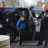 <p>Anselm Park emerges from the police car at the Ann Blanche Smith School as Patrolman Corey Rooney, left, and Chief Robert Francaviglia help him out.</p>