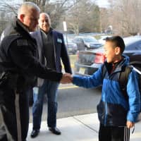 <p>Hillsdale Police Chief Robert Francaviglia congratulates third-grader Anselm Park as Councilman Anthony DeRosa looks on.</p>