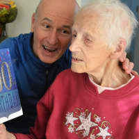 <p>Steve Boyle with his mother, Helen Boyle, as she reads one of her 100th birthday cards.</p>