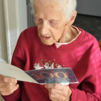 <p>Reading one of her birthday cards aloud.</p>