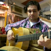 <p>Beacon&#x27;s John Vergara plays one of his own creations in his Lord of the Strings guitar shop.</p>