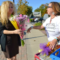 <p>Tyrrells Floral Designer Lisa Mayfield, right, giving out free bouquets in Westwood.</p>