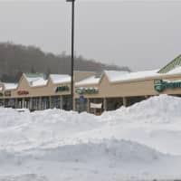 <p>Snow is piled high in the parking lot at Putnam Plaza in Carmel.</p>