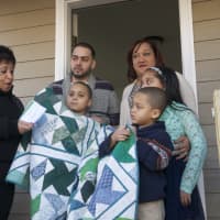 <p>Janet Ortiz (left) presents a gift of a quilt to the Soto family.</p>