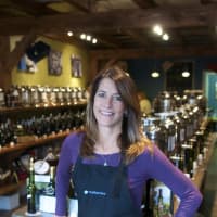 <p>Blue Olive co-owner Beth Canevari with her olive oil and vinegar products.</p>