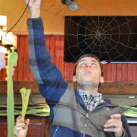 <p>Teacher Assistant Susan Warren of Closter helps Jonathan Yammerino of Closter hang a spider web.</p>