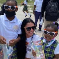 <p>A Hooters Girl poses with a student from Gateway Christian Academy in Bimini</p>