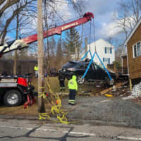 <p>Crews remove a black SUV that crashed into a Grafton home on Wednesday, March 15</p>
