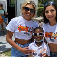 <p>Hooters Girls pose with a student from Gateway Christian Academy in Bimini</p>