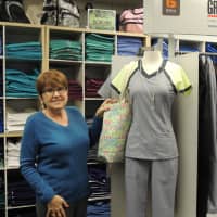 <p>Diane Some with a scrub uniform from her huge inventory of comfortable, wearable work clothes.</p>