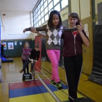 <p>Dows Lane Elementary School second-grader, who is studying about balance and motion in her science class, learned how to walk on a tightwire during a visit by the Amazing Grace Circus.</p>