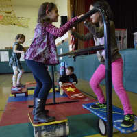 <p>Dows Lane Elementary School second-graders, who are studying about balance and motion in their science classes, balanced on rolla bollas during a visit by the Amazing Grace Circus.</p>
