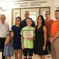 <p>Anthony and his family and coaches after the meeting. Left to right, Chief of Police Michael Colaneri, Sr., sisters Angelina and Giana, parents James and Tina, and coaches Jim Ryan and Tom Hughes.</p>