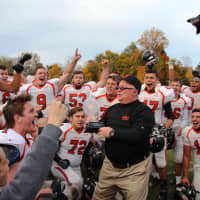 <p>Hasbrouck Heights head coach Nick Delcalzo shares the inaugural NJIC Championship trophy with his team.</p>