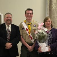 <p>New Eagle Scout John Mullins, center, with his parents, Sean and Kathy Mullins.</p>