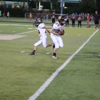 <p>Quarterback Evan Werner hands off to running back Anthony Dilascio early in the game. The Junior Aviators soundly defeated Elmwood Park at Depken Field.</p>