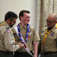 <p>Scoutmaster Bill Severino bestows on John Mullins the Eagle Scout neckerchief as troop co-leader Mike Toscano looks on.</p>