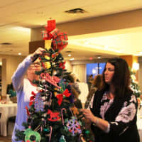 <p>Staff members put the finishing touches on a tree.</p>