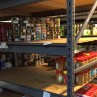 <p>The jars of jelly and fruit collected at Housatonic Community College find a home on this shelf next to peanut butter at the Operation Hope food pantry.</p>
