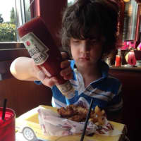 <p>It&#x27;s all about the ketchup! A young patron at the Eveready Diner in Hyde Park gets ready to chow down on chicken tenders and fries served in a paper 1950s-style car.</p>