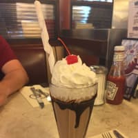 <p>A chocolate ice cream soda is topped with whipped cream and a cherry at the Eveready Diner in Hyde Park.</p>