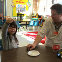<p>Chris Stetson, a scientist with High Touch High Tech, does a magnetism demonstration with Increase Miller Elementary School kindergartner Kayla Orellana.</p>
