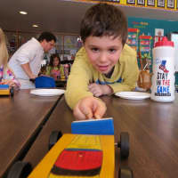 <p>Kindergartner Owen Kurlanzik demonstrated the force of magnetism by moving a toy car using two repelling magnets.</p>