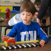 <p>Wesley Cotrone, a kindergartner at Increase Miller Elementary School, uses a device to practice the forces of pulling and pushing.</p>