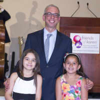 <p>Former patients Mia and Sophia stand with honoree Dr. Adam Levy.</p>