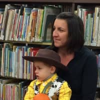 <p>Sebastian Zak, dressed as Woody from &quot;Toy Story,&quot; listens to story time with his mom Agnes.</p>