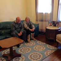 <p>A married couple sits in their newly furnished home provided by Making-It-Home.</p>