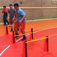 <p>Athletes perform lateral jumps before partnering up at practice Monday.</p>